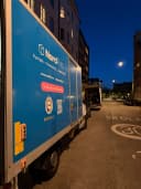 Nordflytts flyttbil på en gata i Stockholm i skymning under en flytt mellan städer.