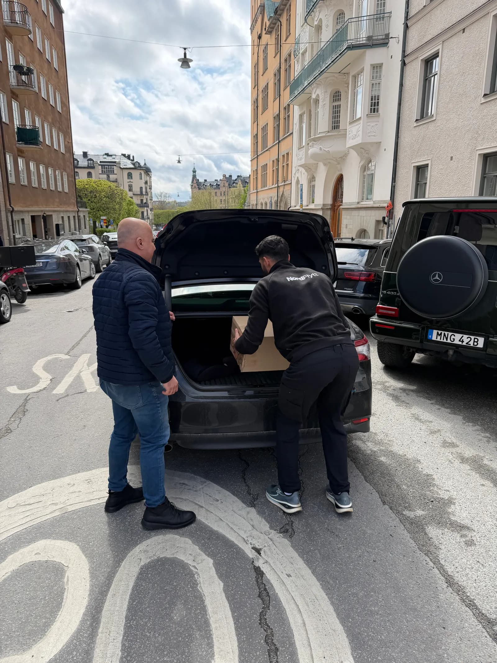 Flyttare lastar bohag i en flyttbil på en gata i Stockholm.
