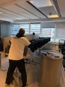 Flyttare från Nordflytt plastar in inredning vid en kontorsflytt med utsikt över Stockholm.