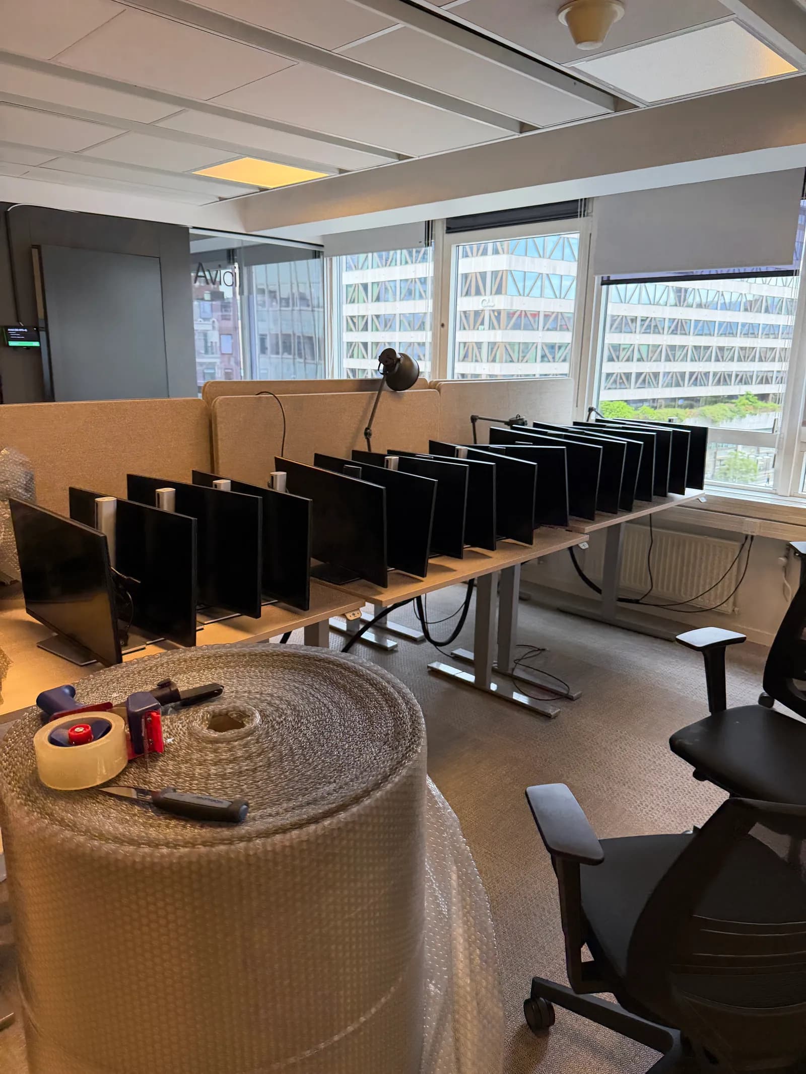 Kontorsskärmar och bohag förbereds för packning vid en kontorsflytt.