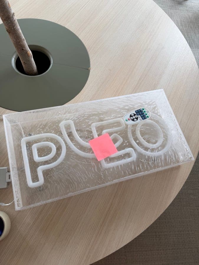 Pleos neonskylt emballerad på ett bord inför kontorsflytten