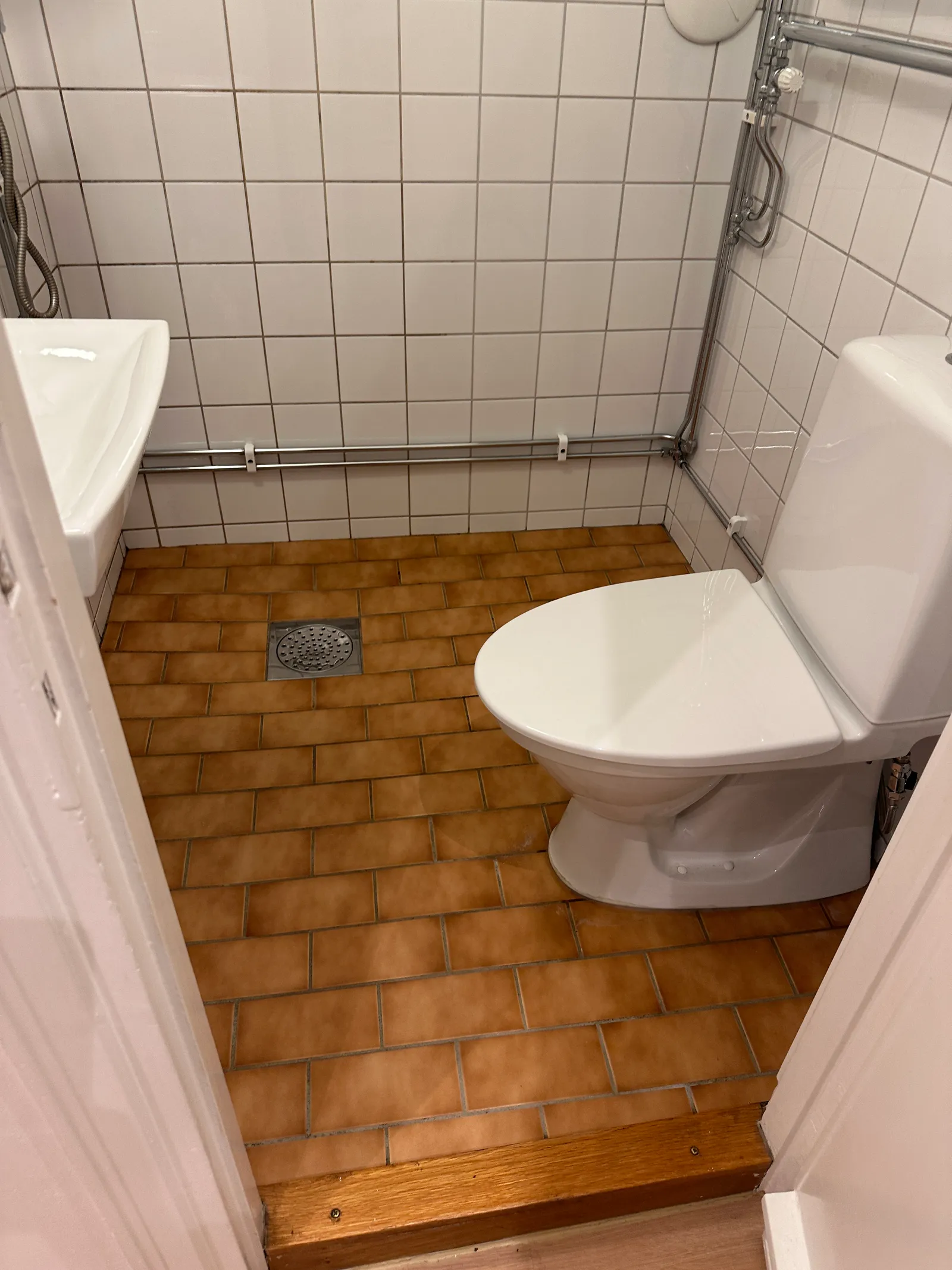 Putsat handfat och glasvägg i ett rengjort badrum.