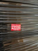 Inplastat gods märkt FRAGILE – Handle with care – inför transport.