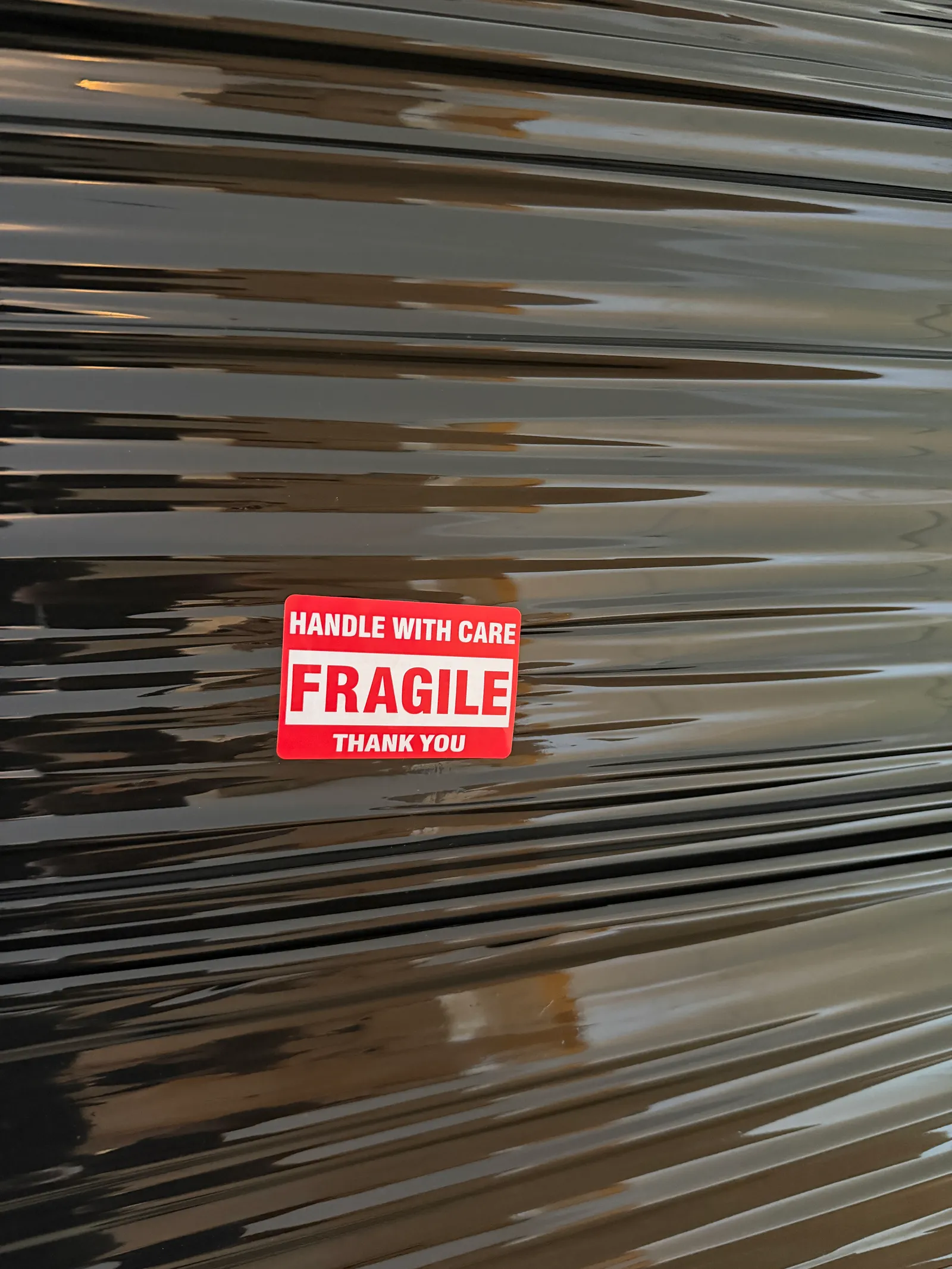 Inplastat gods märkt FRAGILE – Handle with care – inför transport.