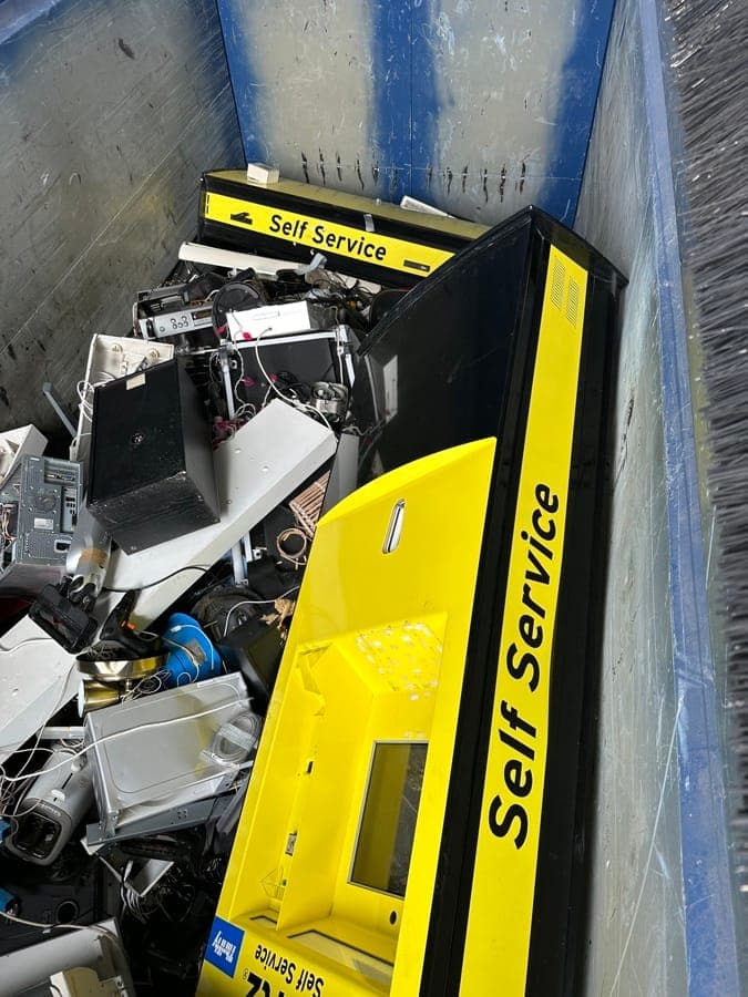 En av Hertz gamla gula self-service-kiosker i en container med elektronikavfall