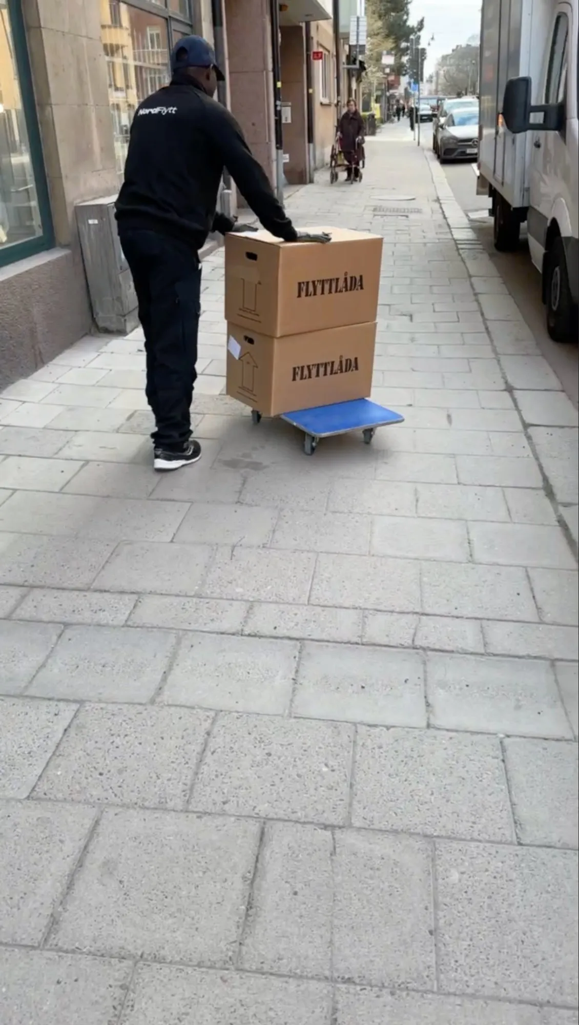 Nordflytt-personal rullar kartonger på pirra mot lastbilen