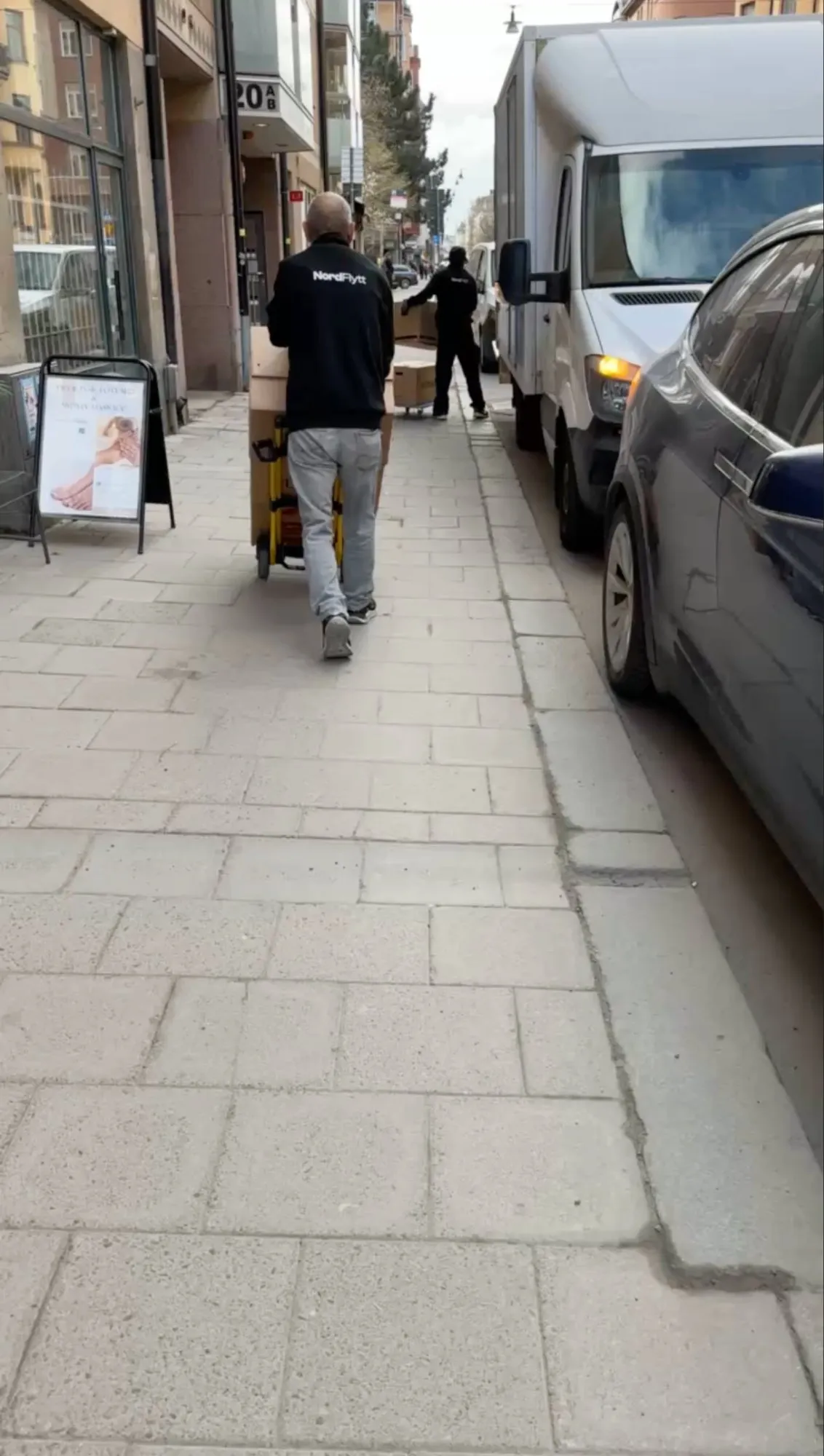 Två Nordflytt-personal på väg mot lastbilen